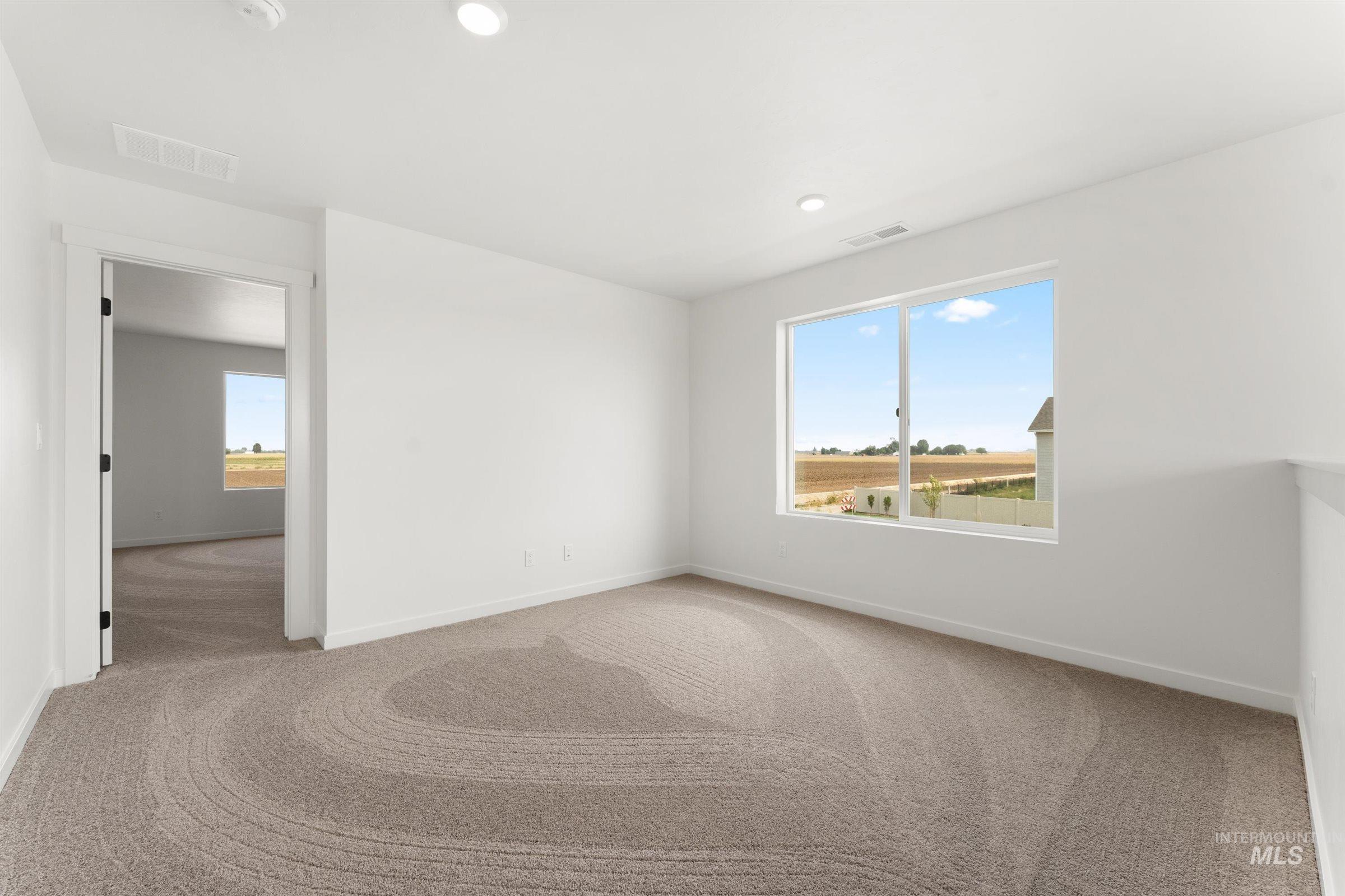 1076 East Exploration Drive Kuna, ID 83634 - Photo 12 of 29 Carpeted spare room featuring baseboards and recessed lighting