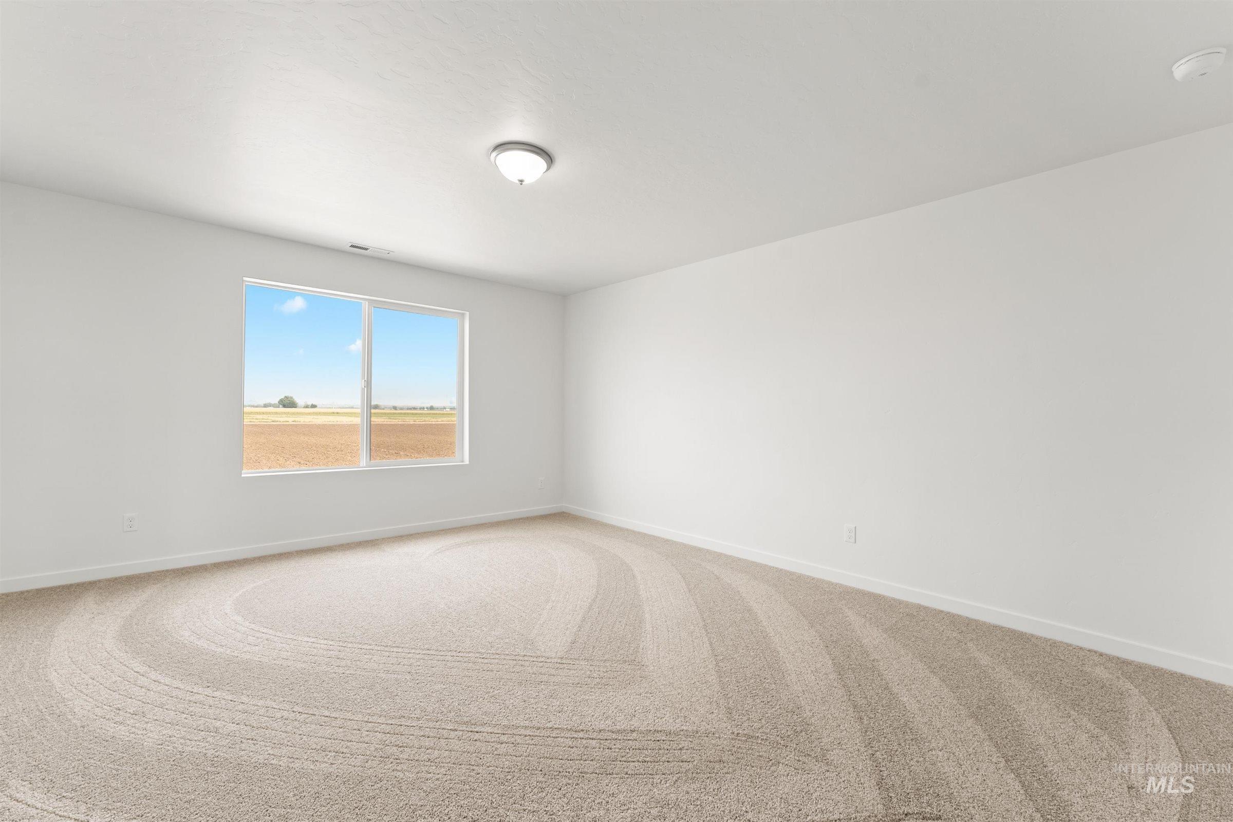 1076 East Exploration Drive Kuna, ID 83634 - Photo 15 of 29 Empty room with carpet flooring and baseboards