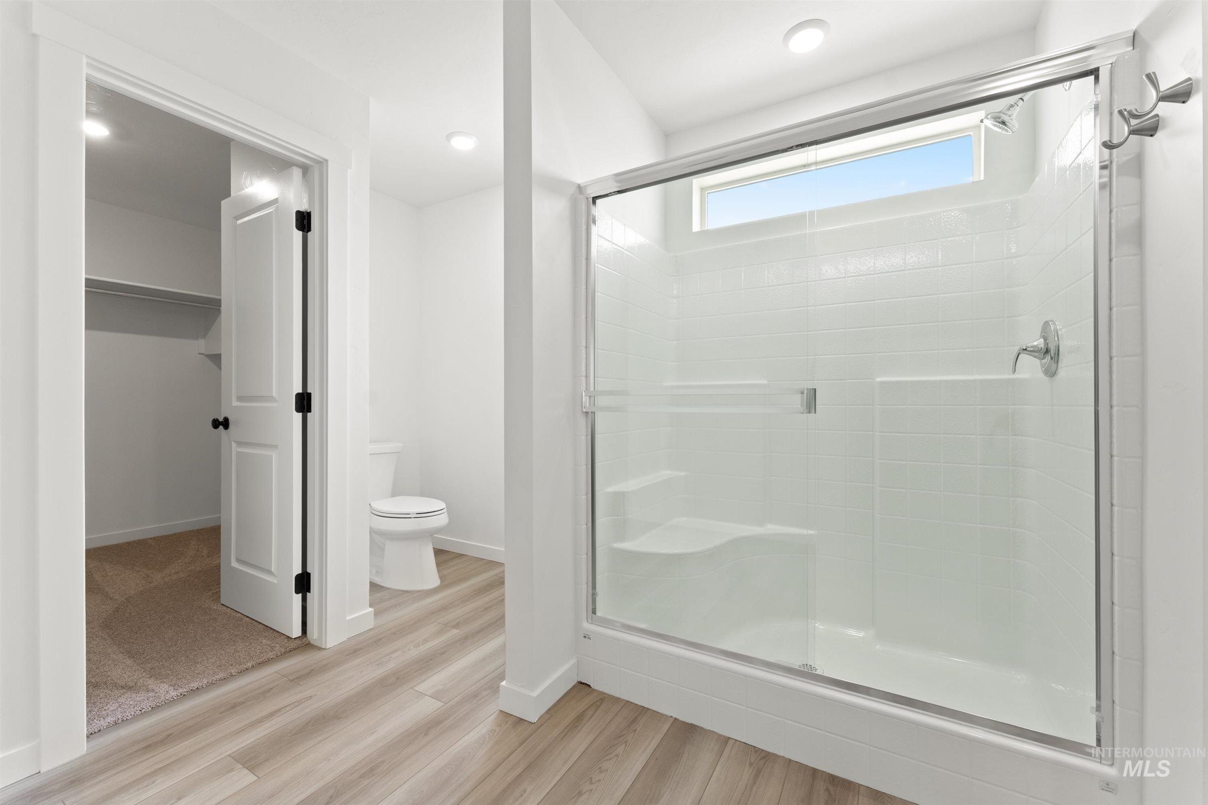 1076 East Exploration Drive Kuna, ID 83634 - Photo 18 of 29 Full bathroom with a shower stall, light wood finished floors, a spacious closet, and recessed lighting