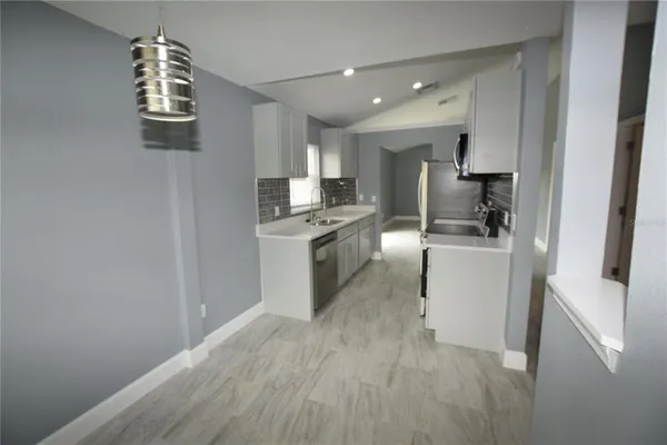 a kitchen with cabinets and wooden floor