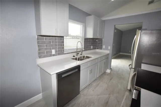 a kitchen with stainless steel appliances granite countertop a sink stove and cabinets