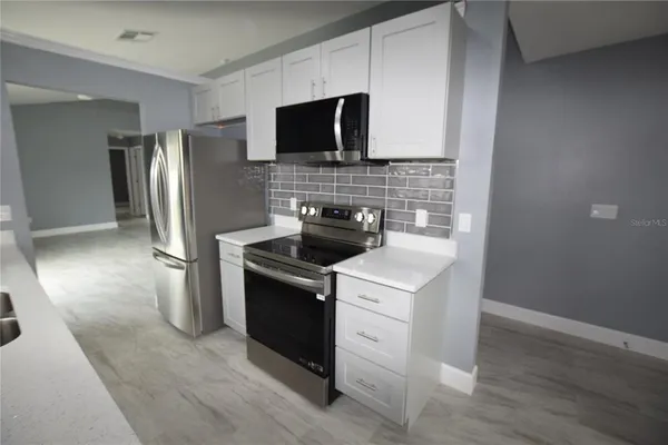 a kitchen with stainless steel appliances a stove microwave and refrigerator