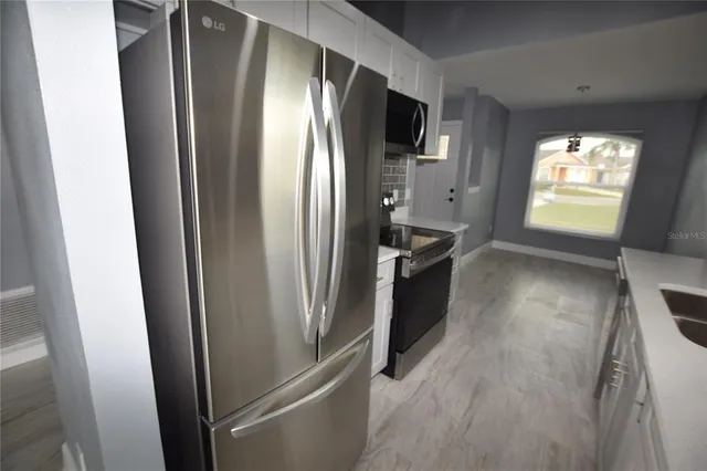 a kitchen with stainless steel appliances a refrigerator and a window