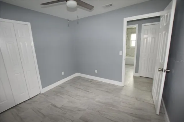 a view of an empty room with a chandelier fan