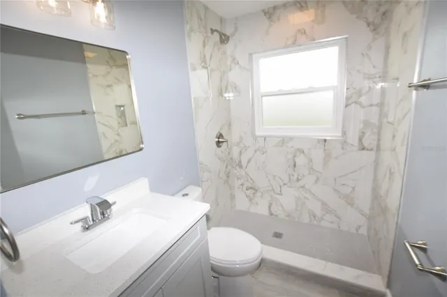 a bathroom with a sink toilet and shower