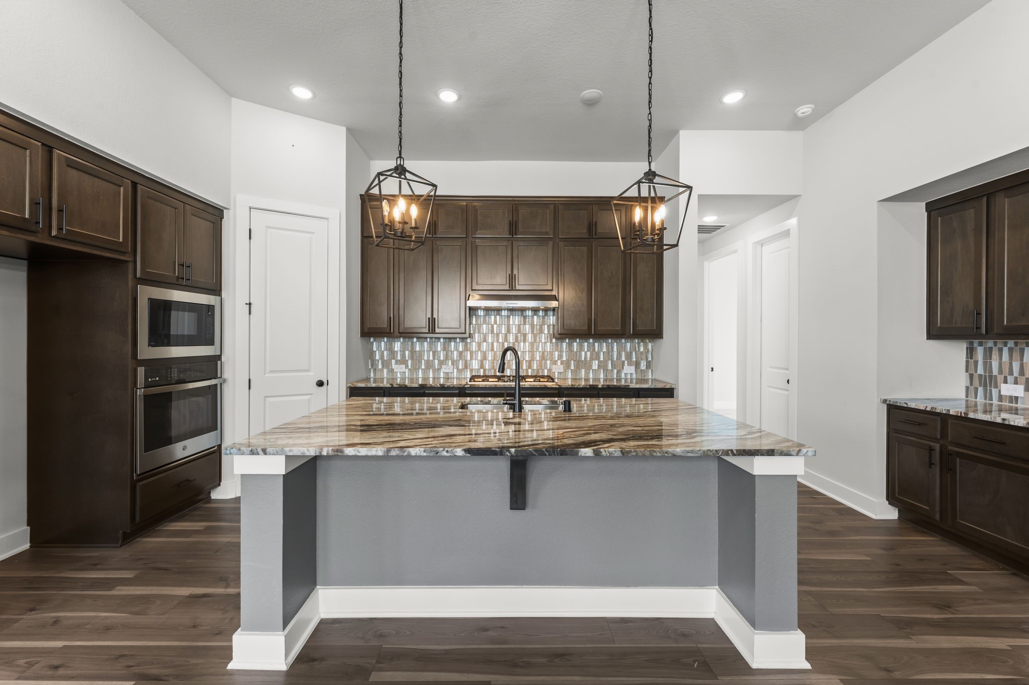 17151 Sandstone Street Conroe, TX 77302 - Photo 12 of 38 a kitchen with kitchen island a sink stainless steel appliances and wooden floor