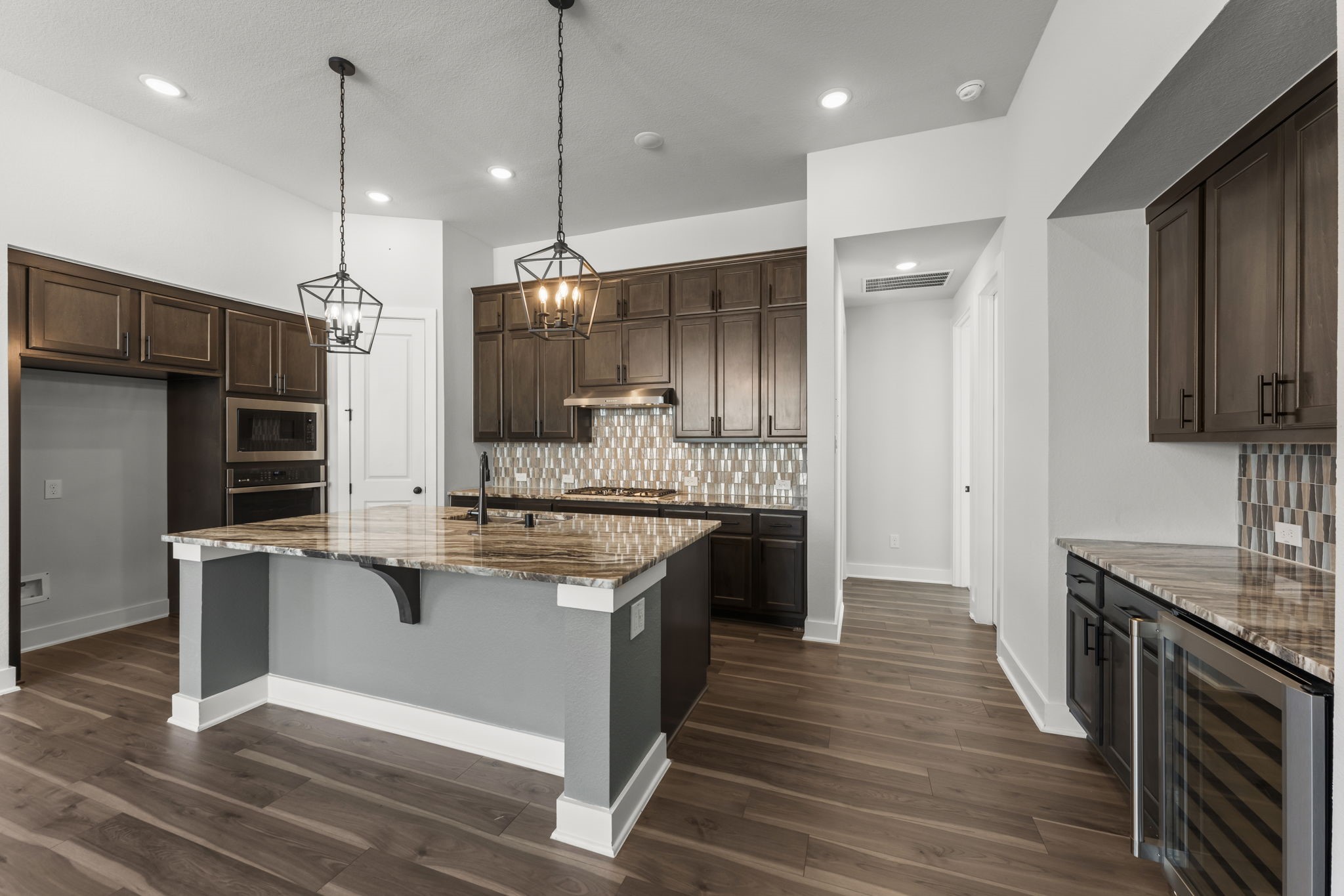 17151 Sandstone Street Conroe, TX 77302 - Photo 13 of 38 a kitchen with stainless steel appliances granite countertop a sink a stove and a wooden floors