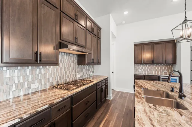 a kitchen with stainless steel appliances granite countertop a stove sink and cabinets