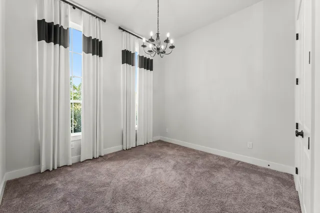 a view of a room with a chandelier fan and closet
