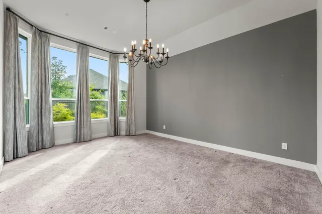 a view of a livingroom with a chandelier fan and windows