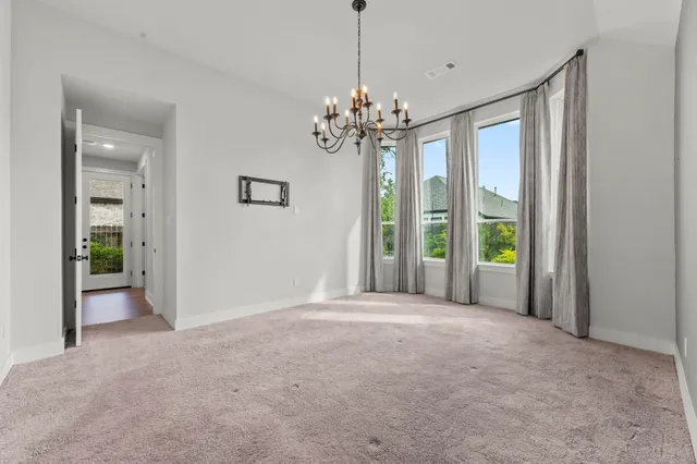 a view of a livingroom with a chandelier fan and windows