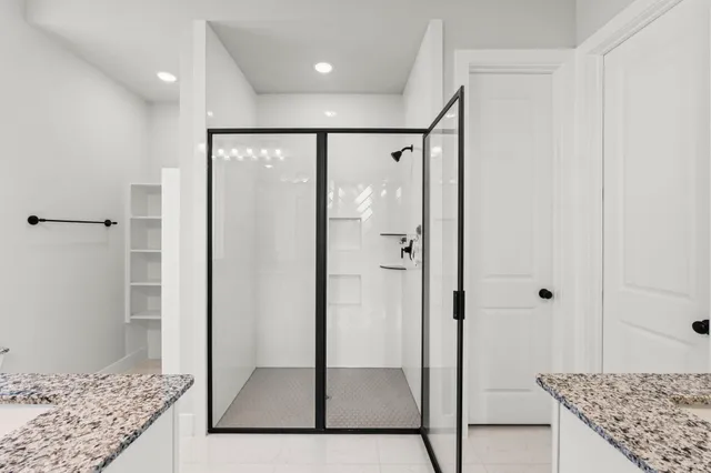 a bathroom with a granite countertop sink a mirror and shower