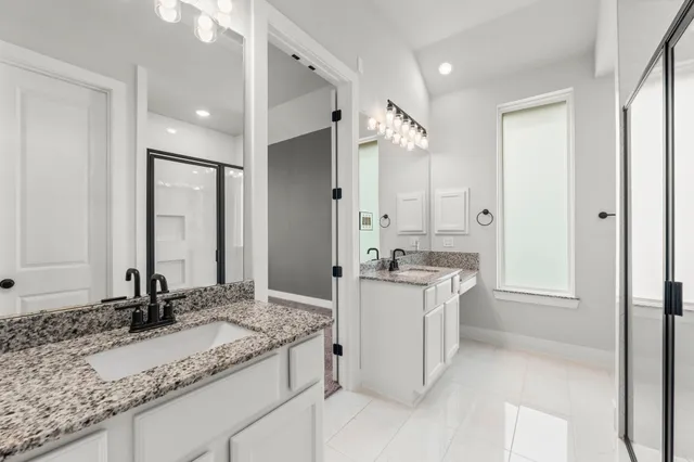 a bathroom with a granite countertop double vanity sink mirror and