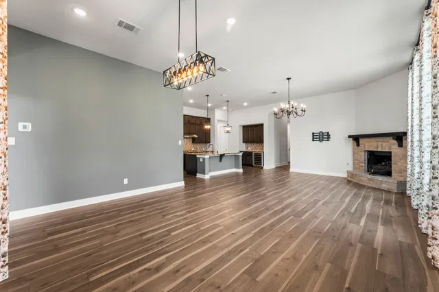 a view of a room with wooden floor and kitchen view