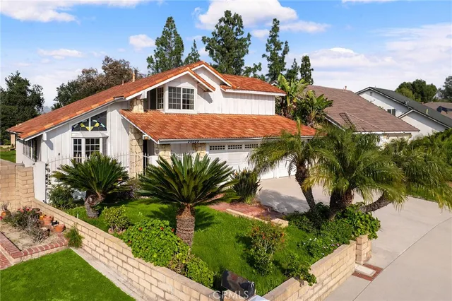a view of a house with a yard and potted plants