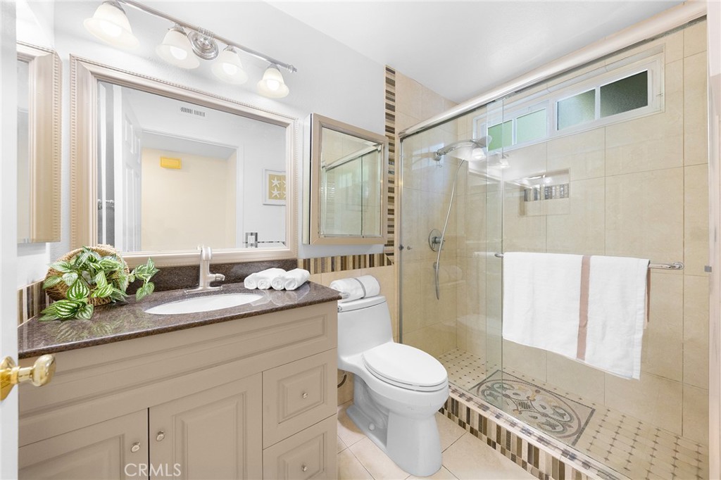 20329 Rim Ridge Road Walnut, CA 91789 - Photo 36 of 46 a bathroom with a granite countertop sink toilet a mirror a vanity and shower