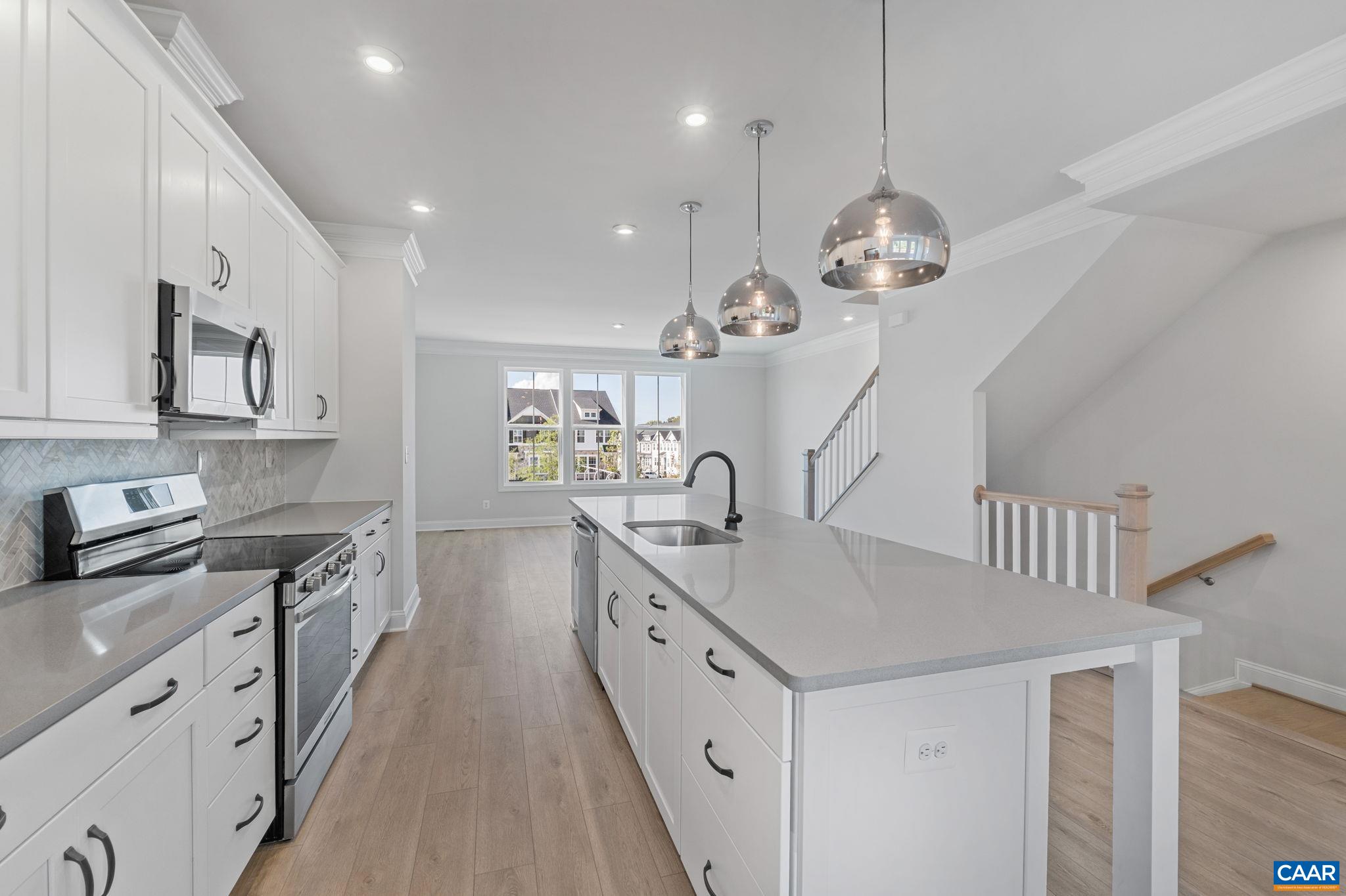 107 Park Ridge Drive Crozet, VA 22932 - Photo 14 of 42 a large kitchen with kitchen island white cabinets and wooden floor