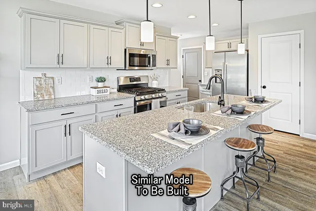 a kitchen with stainless steel appliances granite countertop a sink a stove a kitchen island with chairs and cabinets
