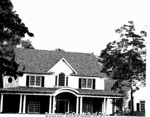a view of a white house with large windows and a large tree