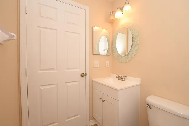 a bathroom with a sink and mirror with toilet