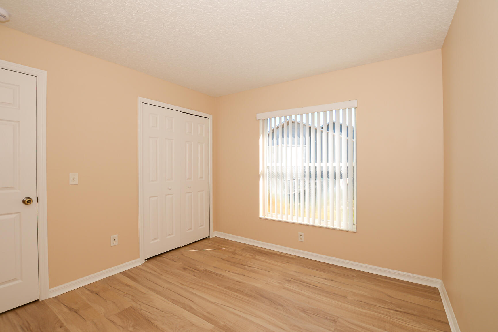 2201 Southeast Carnation Road Port St. Lucie, FL 34952 - Photo 27 of 37 an empty room with wooden floor and windows