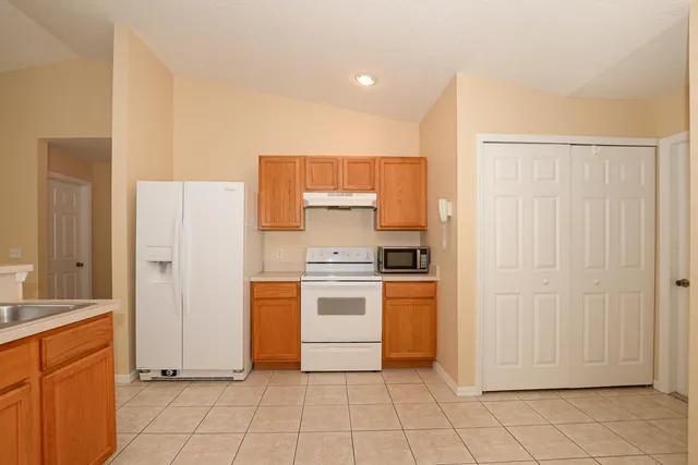 a kitchen with white cabinets and white appliances