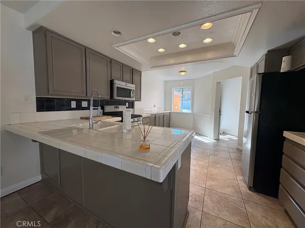 a kitchen with stainless steel appliances granite countertop a sink a refrigerator and a stove