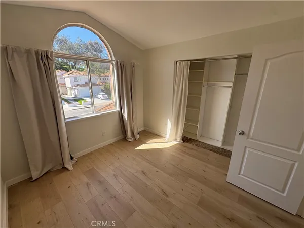 an empty room with wooden floor and a window