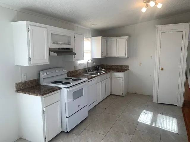a kitchen with a stove sink and cabinets