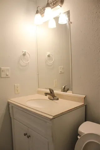 a bathroom with a sink toilet and a mirror