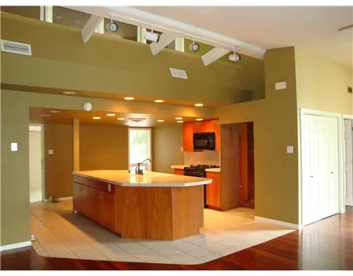 a dining hall with stainless steel appliances kitchen island granite countertop a refrigerator and a sink