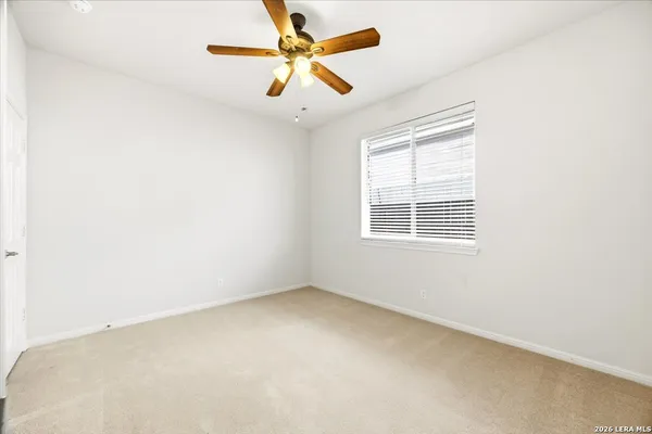 an empty room with a window and a fan