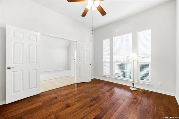 an empty room with wooden floor and windows
