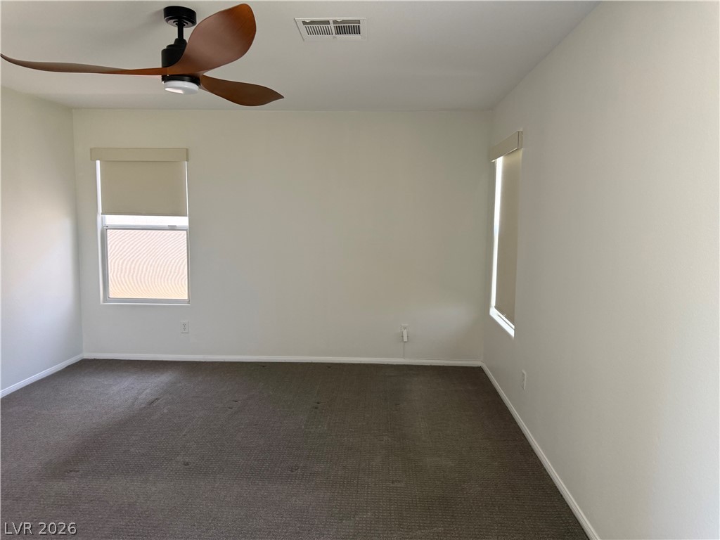 1141 Cathedral Ridge Street Henderson, NV 89052 - Photo 47 of 77 This spacious room features carpeted flooring and windows with roller shades, offering a versatile living space.