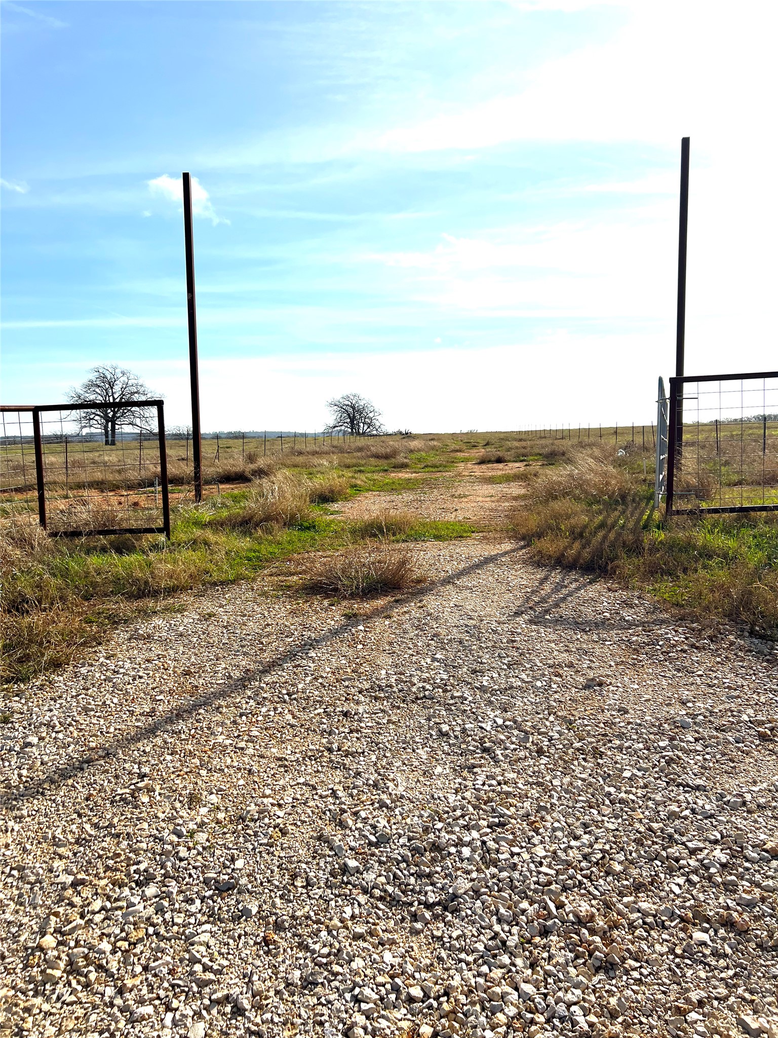 View of dirt / gravel road featuring a view of rural / pastoral area