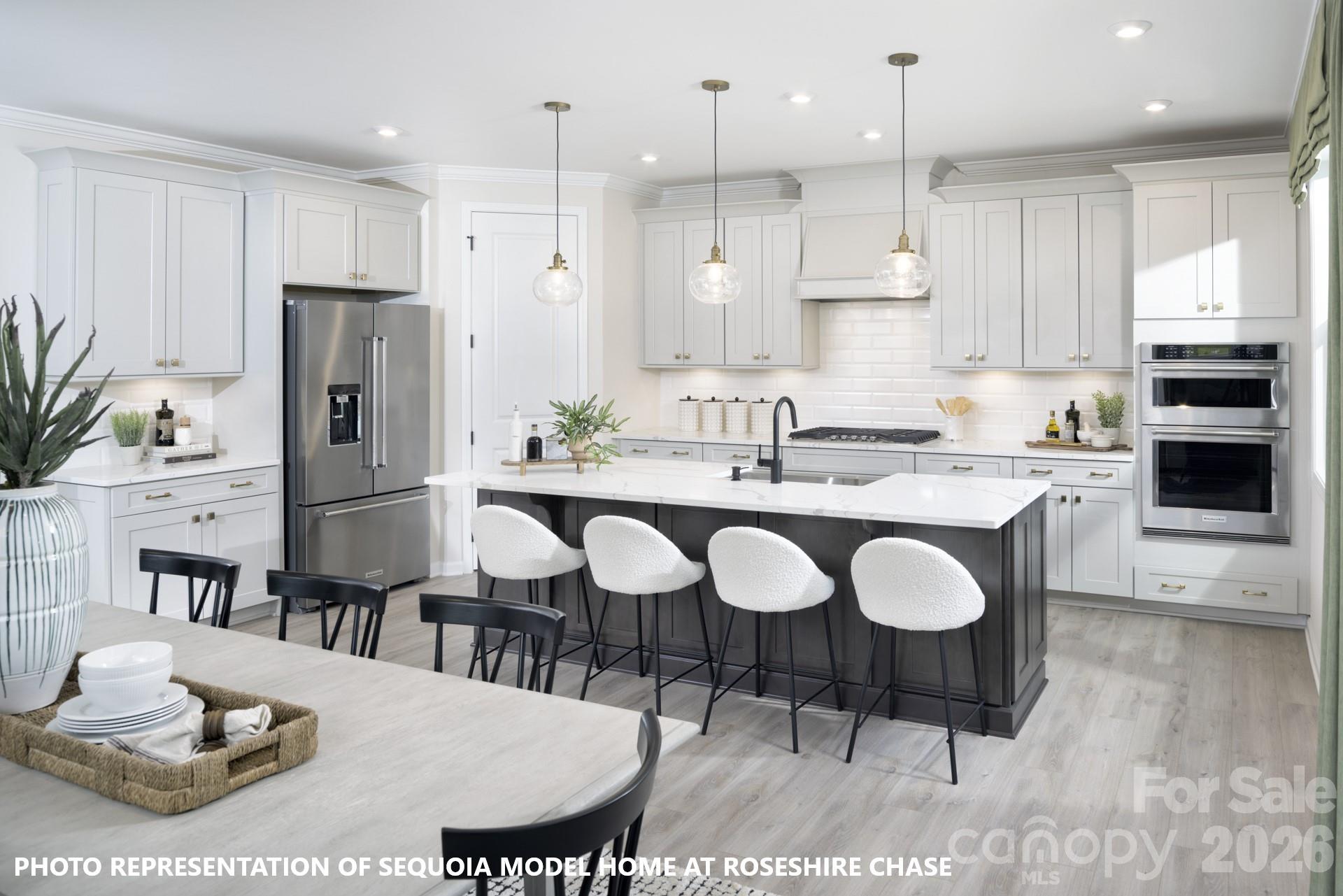 9969 Cask Way Huntersville, NC 28078 - Photo 11 of 36 a kitchen with a dining table chairs and refrigerator