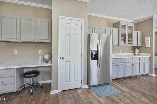 a kitchen with white cabinets and wooden floors