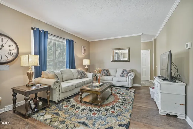 a living room with furniture a flat screen tv and a window