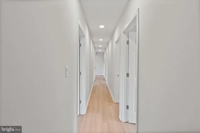 a view of a hallway with wooden floor