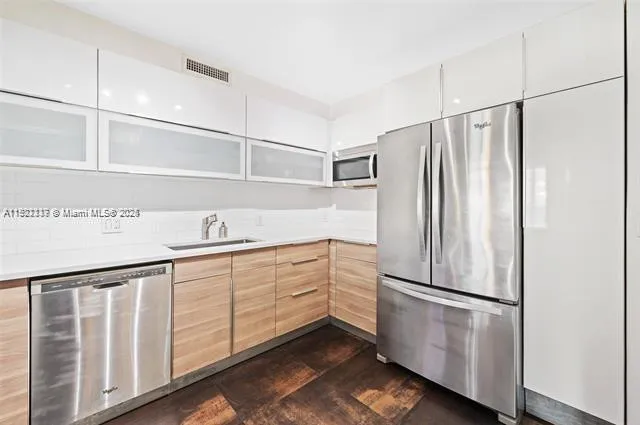 a kitchen with white cabinets and white stainless steel appliances