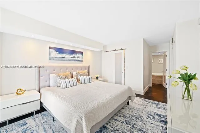 a bedroom with a bed a couch and paintings on the wall