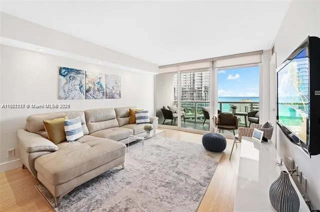 a living room with furniture a large window and a flat screen tv