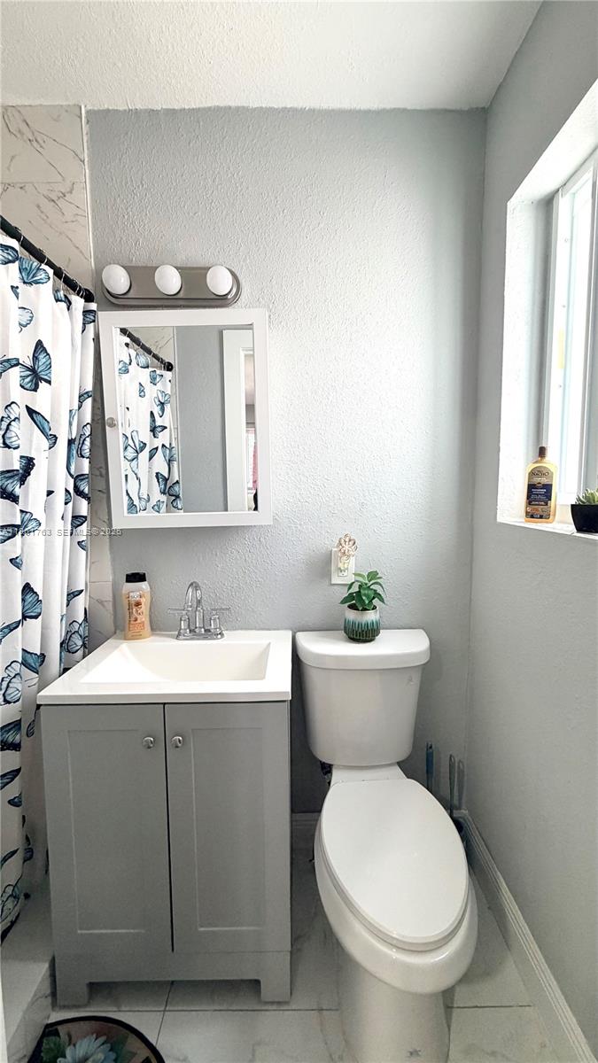 598 East 41st Street Hialeah, FL 33013 - Photo 11 of 15 a bathroom with a toilet sink and mirror