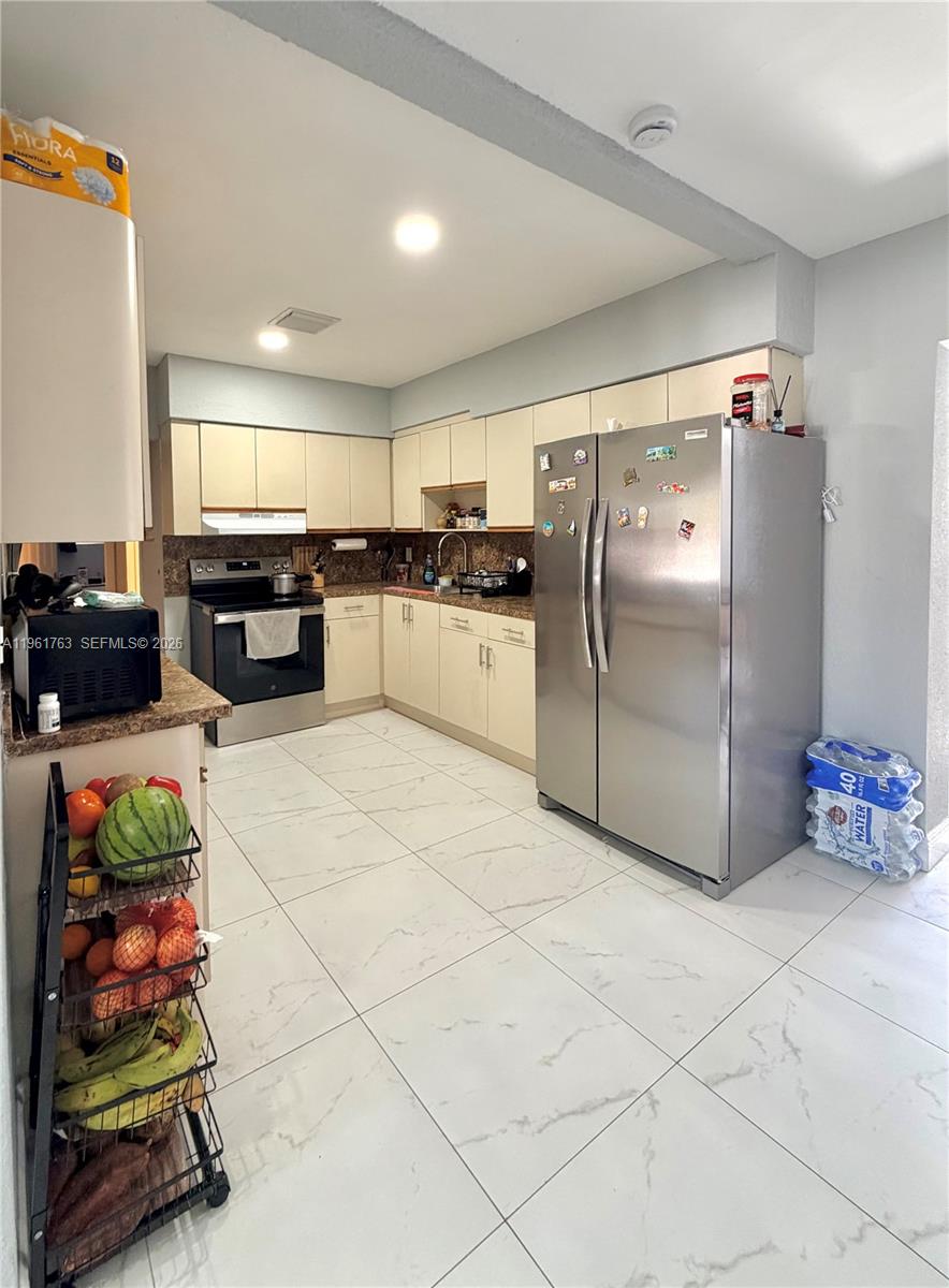 598 East 41st Street Hialeah, FL 33013 - Photo 4 of 15 a kitchen with stainless steel appliances granite countertop a refrigerator and a stove top oven