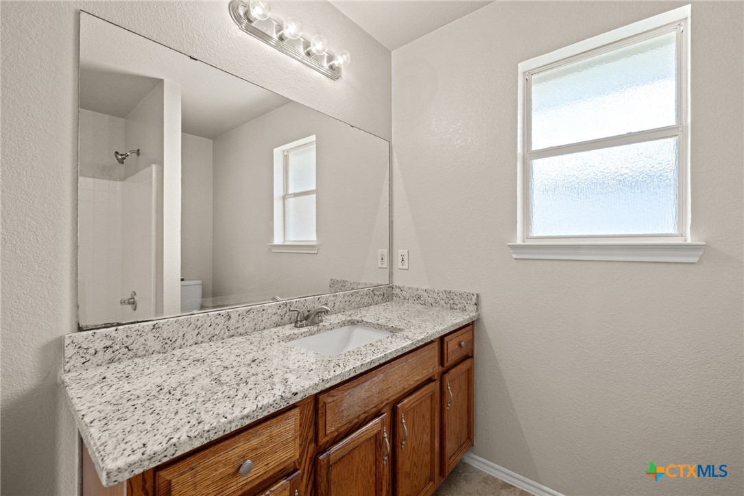 214 Timber Ridge Drive Nolanville, TX 76559 - Photo 17 of 31 a bathroom with a granite countertop sink and a window