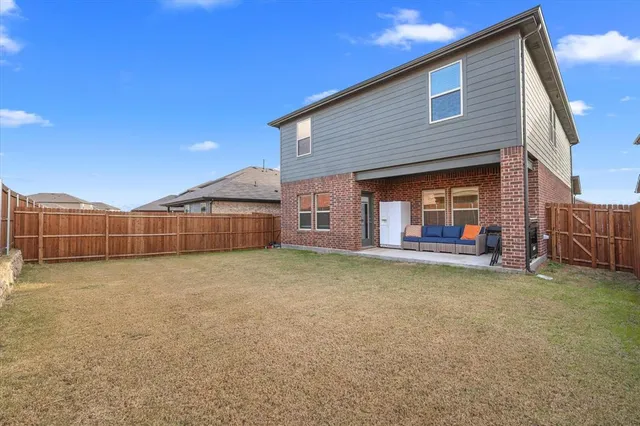 a view of a house with a yard and wooden fence