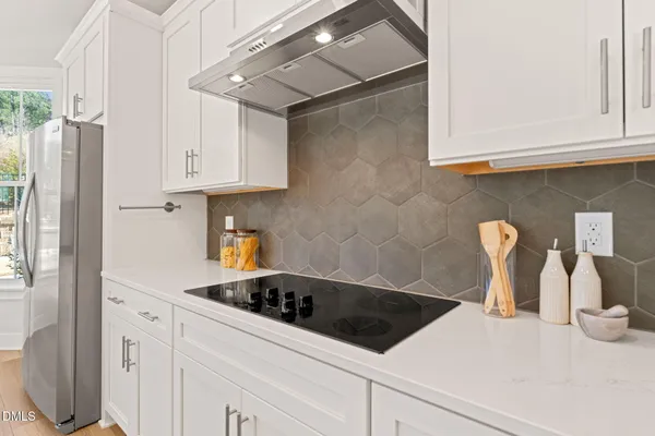 a kitchen with stainless steel appliances granite countertop a sink a stove and a refrigerator