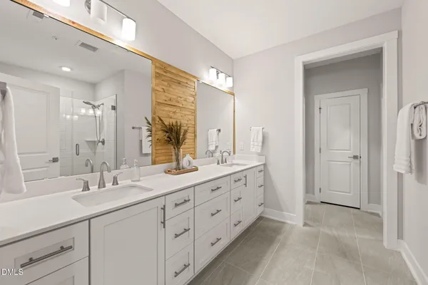 a bathroom with double sink and a mirror