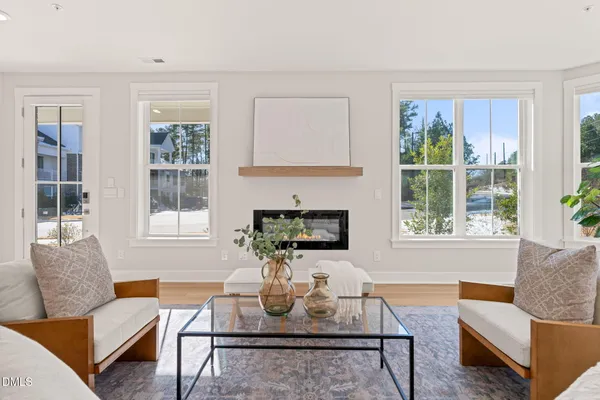 a living room with furniture a large window and a fireplace