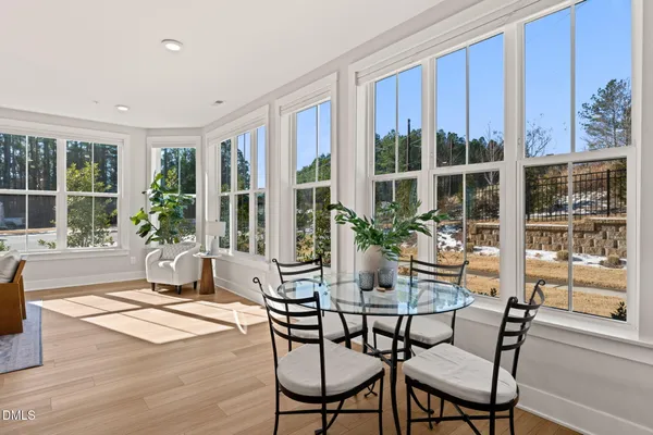a view of a dining room with furniture large windows and wooden floor